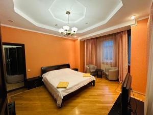 a bedroom with orange walls and a bed and a television at VerhoVilla in Verkhovyna