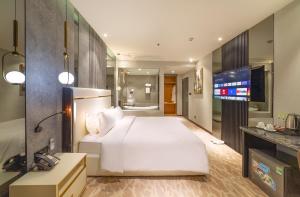 a hotel room with a bed and a television at New Century Dalat Hotel in Da Lat