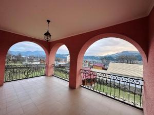 a balcony with three arched windows and a view at VerhoVilla in Verkhovyna