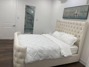 a bedroom with a white bed with a white comforter at luxury & Spacious 2 bedrooms basement serviced apartment in Brampton
