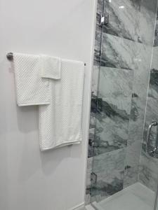een badkamer met een douche, een toilet en handdoeken bij luxury & Spacious 2 bedrooms serviced apartment in Brampton