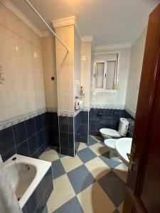 ein Badezimmer mit 2 WCs, einer Badewanne und 2 Waschbecken in der Unterkunft REYES-SOL Setenil in Setenil de las Bodegas