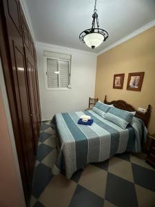 Schlafzimmer mit einem Bett mit blauer Decke in der Unterkunft REYES-SOL Setenil in Setenil de las Bodegas
