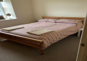 a bedroom with a bed with two towels on it at Outlook Cottage in Wandylaw