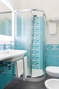 a bathroom with a glass shower and a sink at Hotel Centrale Miramare in Rimini