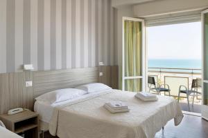 a bedroom with a bed with a view of the ocean at Hotel Centrale Miramare in Rimini