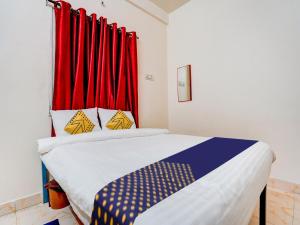 Un pat sau paturi într-o cameră la OYO R J Hotel