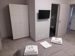 a bathroom with white towels on the floor and a television at MOM'S HOUSE VOMERO in Naples