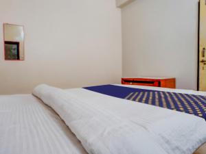 Un pat sau paturi într-o cameră la OYO R J Hotel