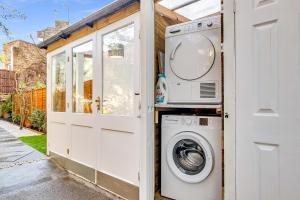 a washer and dryer next to a house at Stunning Studio in heart of LDN with garden in London