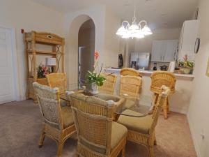 a dining room with a table and wicker chairs at Bahama Bay, Grand Bahama spacious 3-bedroom Penthouse near Disney in Kissimmee
