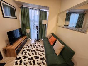a living room with a green couch and a television at House of Joe - City Center in Baguio