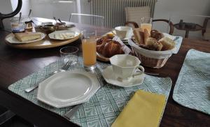 a table with a plate of bread and glasses of orange juice at Le Logis du Pradet in Moncrabeau