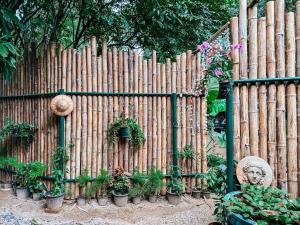 een houten hek met een standbeeld en potplanten bij Baan Suanthip Homestay - Aoluek Natural Retreat in Ao Luk