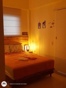 ein Schlafzimmer mit einem Bett mit einer Lampe in der Unterkunft Centro da cidade, Teresópolis. Várzea. in Teresópolis