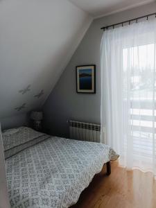 een slaapkamer met een bed en een raam bij Sielski Domek pod Karpaczem in Miłków