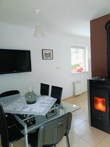 sala de estar con mesa de cristal y chimenea en Sielski Domek pod Karpaczem en Miłków