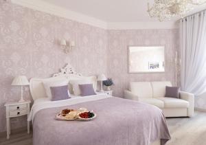 Un dormitorio con una cama con una bandeja de comida. en Palais Miramar Imperial Croisette en Cannes