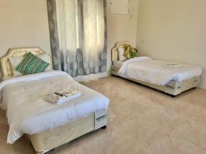 two beds sitting in a room with at Jabal Shams Al-Salam house in Sa‘ab Banī Khamīs