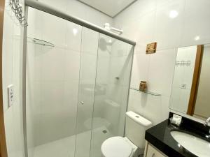 a bathroom with a shower and a toilet and a sink at Refugio Urbano in Goiânia