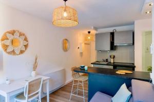 cocina y sala de estar con mesa y sillas en Appartement rénové, calme et proche des plages., en Sète