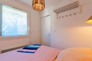 1 dormitorio con cama y ventana en Appartement rénové, calme et proche des plages., en Sète