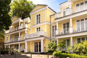 a yellow building with a sign on it at Vju Hotel Rügen in Göhren