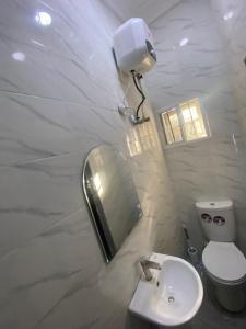a bathroom with a sink and a mirror and a toilet at Excel suite by Home Glides in Lekki