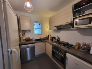 a small kitchen with a stove and a refrigerator at Sur le bassin d'Arcachon in Lanton