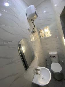 a bathroom with a toilet and a sink and a mirror at Excel suite by Home Glides in Lekki