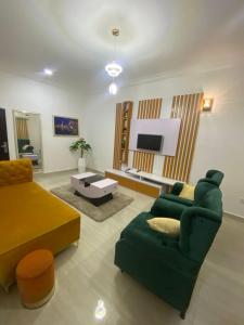 a living room with a green couch and a tv at Excel suite by Home Glides in Lekki