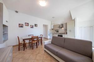 een woonkamer en een keuken met een bank en een tafel bij Casetta Nociarelle in Piegaro