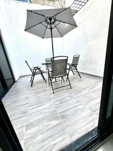 a patio with a table and chairs and an umbrella at Depa Lunero in Cancún