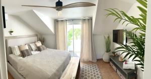 una camera da letto con un letto e un ventilatore a soffitto di Escale Caraïbes ad Anse Marcel