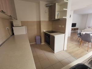 a small kitchen with a table and a white refrigerator at Apartment Mejdan in Tuzla