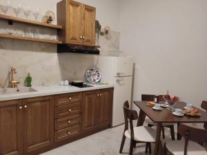 a kitchen with wooden cabinets and a table and a refrigerator at City Center Suites in Karpathos