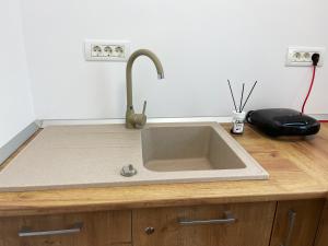a kitchen sink with a faucet on a counter at Central Residence in Târgu Jiu