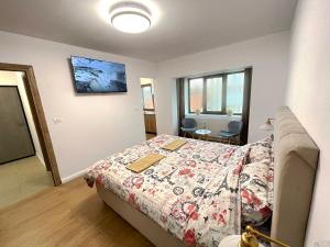 a bedroom with a bed with a comforter on it at Central Residence in Târgu Jiu