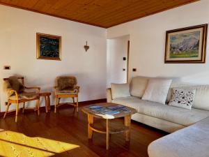ein Wohnzimmer mit einem Sofa und einem Tisch in der Unterkunft Lussuoso Chalet in centro a 4 min a piedi dalle piste da sci in Tarvis