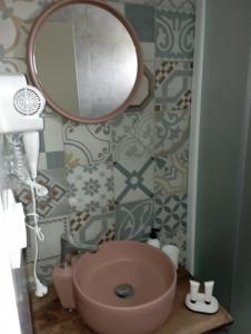 a bathroom with a pink sink and a mirror at sylias village in Skála Korinoú