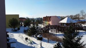 利普托斯基米庫拉斯的住宿－Tatralandia Apartmán，一座有积雪覆盖的城镇,有一座建筑和一座桥梁