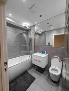 a bathroom with a toilet and a shower and a sink at Elegant Central Brentwood Flat in Brentwood