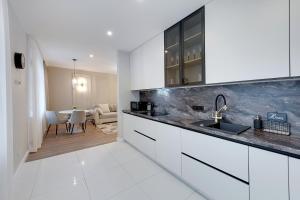 葉爾加瓦的住宿－Central Luxury Apartments，一间厨房,配有白色橱柜和一间餐厅