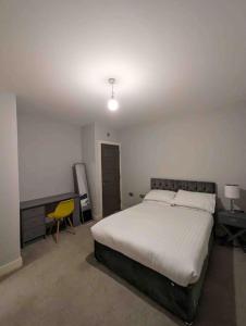 a bedroom with a large bed and a desk at Elegant Central Brentwood Flat in Brentwood