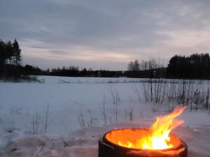 eine Feuerstelle in einem Feld mit Schnee in der Unterkunft Villa Gallela in Rovaniemi