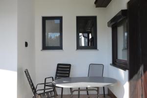 einen Tisch und Stühle in einem Zimmer mit Fenstern in der Unterkunft Kinderlachen garantiert in Lutzmannsburg