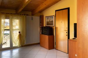 a living room with a door and a tv and a window at Appartamento Il Glicine a Pesaro in Pesaro