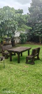 una mesa de picnic y un banco en el césped en ocean palace self catering lodge, en Durban