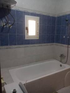 諾克少的住宿－Chambre Chez Jean，带浴缸的浴室和窗户
