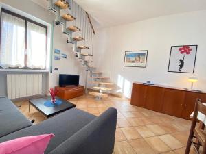 sala de estar con sofá y escalera de caracol en La Discografica, Elegante e Spaziosa per Gruppi, en Trezzano Rosa